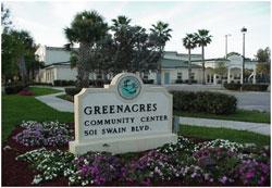 Greenacres Community Center sign surrounded by flowers